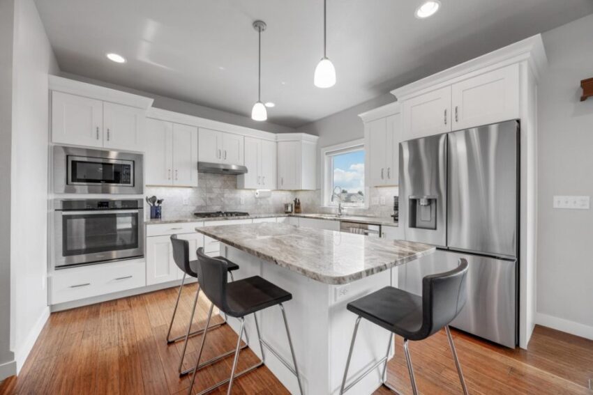 Kitchen with white cabinets and spacious island with seating.