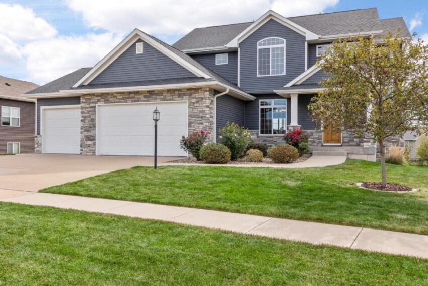 Front of home with dark blue siding and lamp post.