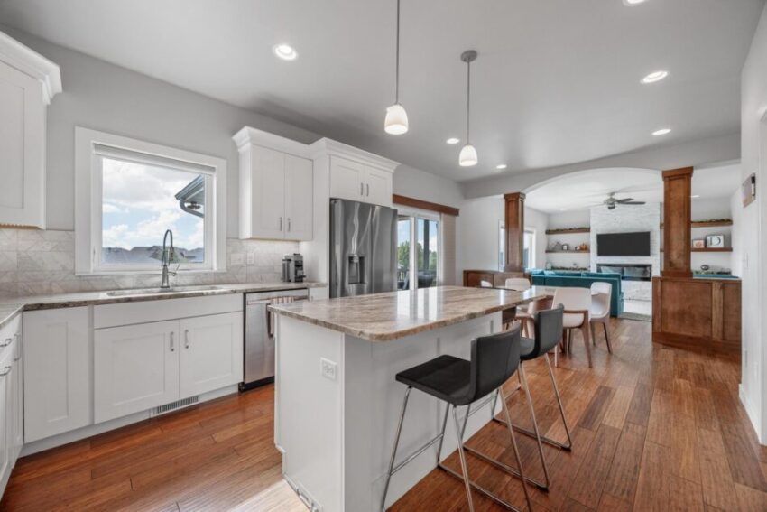 Kitchen with wood floors and pendant lights above island.