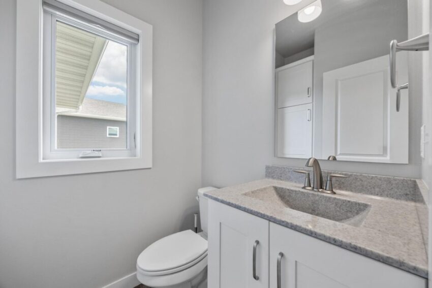 Bathroom 1, with white cabinet, light walls, and white trim.