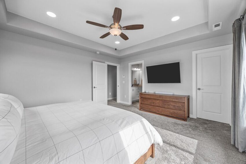 Bedroom 2, with light walls, white trim, carpet, and ceiling fan.