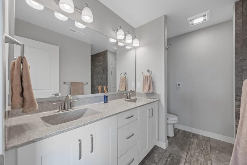 Bathroom 2, with double sinks and white cabinets.