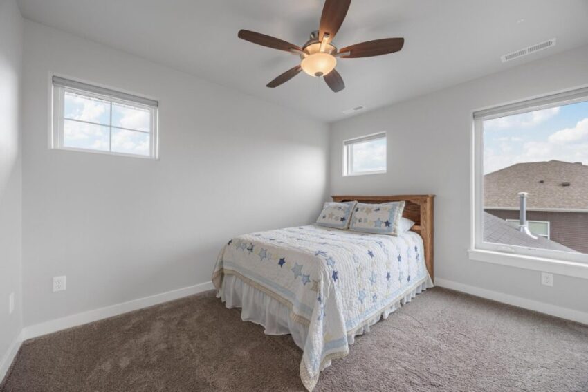 Bedroom 4, with high windows, ceiling fan, and carpeted floor.