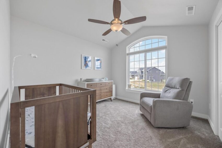 Bedroom 5, with large window, ceiling fan, peaked ceiling, and carpet.