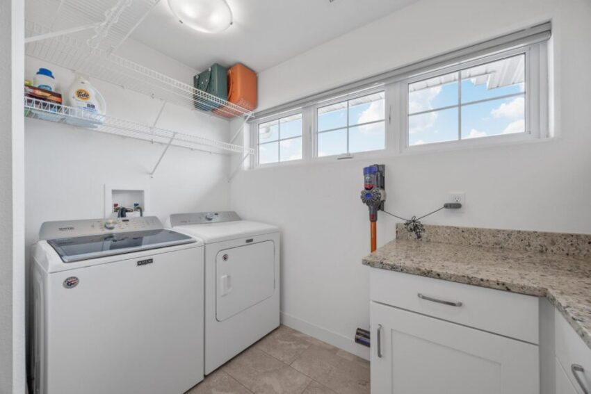 Washer and dryer in laundry room with wire shelves overhead.