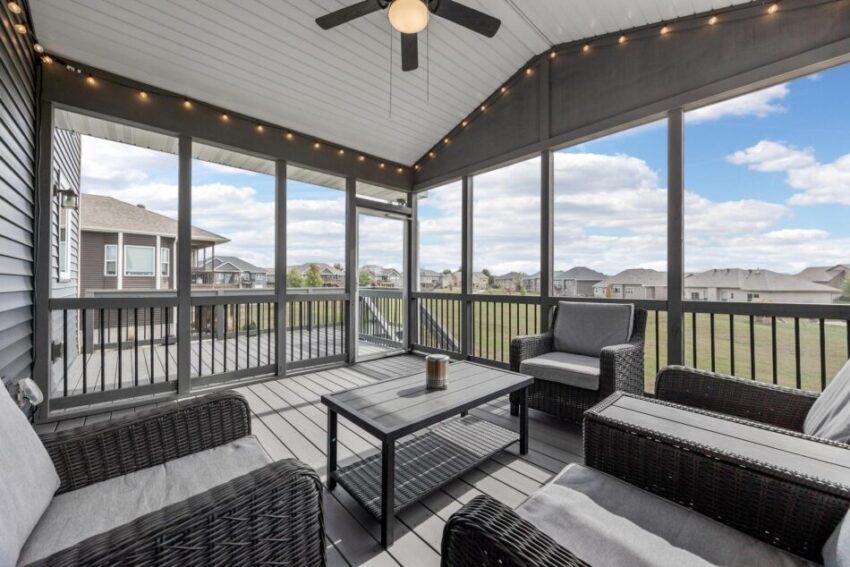 Screened back porch with ceiling fan and gray plank floor.
