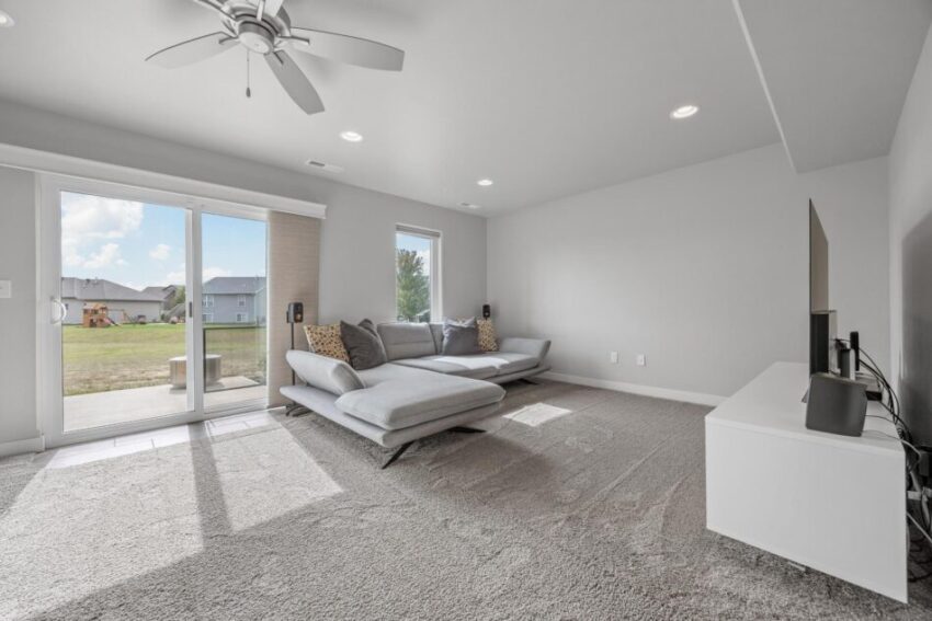 Finished lower level with ceiling fan and wall to wall carpet.