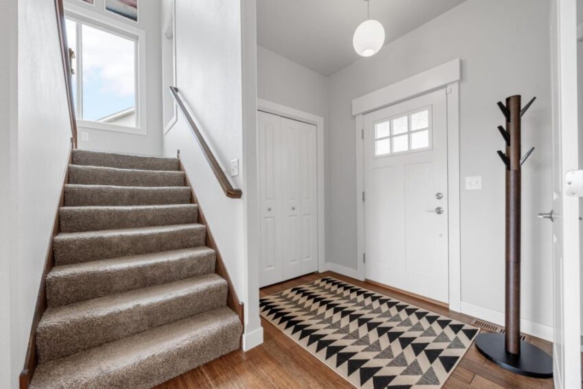 Entryway with carpeted stairs and pendant light.
