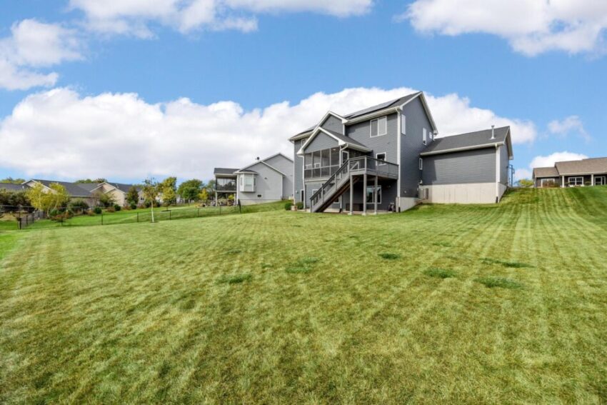 View of house from the distance surrounded by lawn.