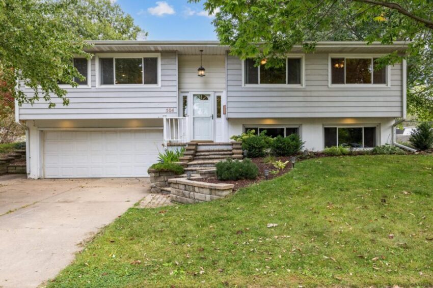 Front of home with two-car garage and landscaping around entryway stairs.