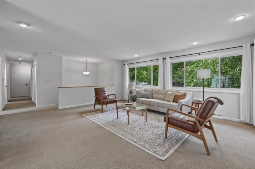 Living room with built-in ceiling lights, white trim, and floor-to-ceiling curtains.