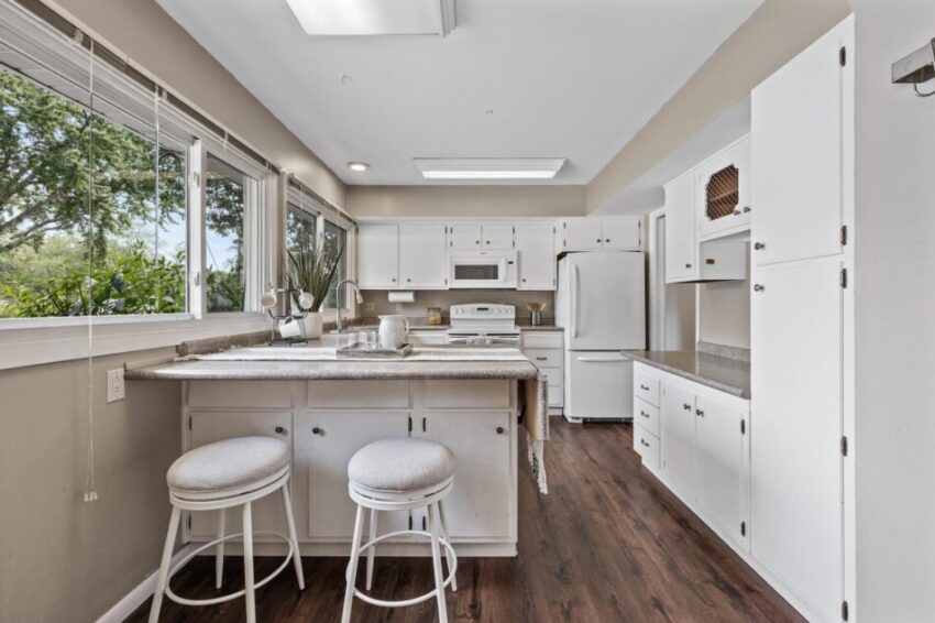 Kitchen with eat-in breakfast bar, several large windows, and overhead lights.