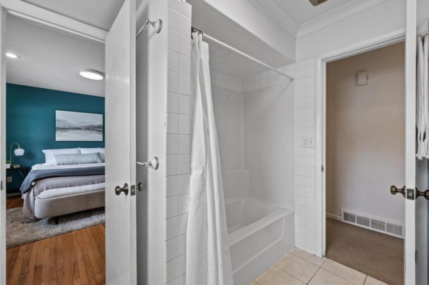 Jack and Jill bathroom with shower tub combo surrounded by a white tile.