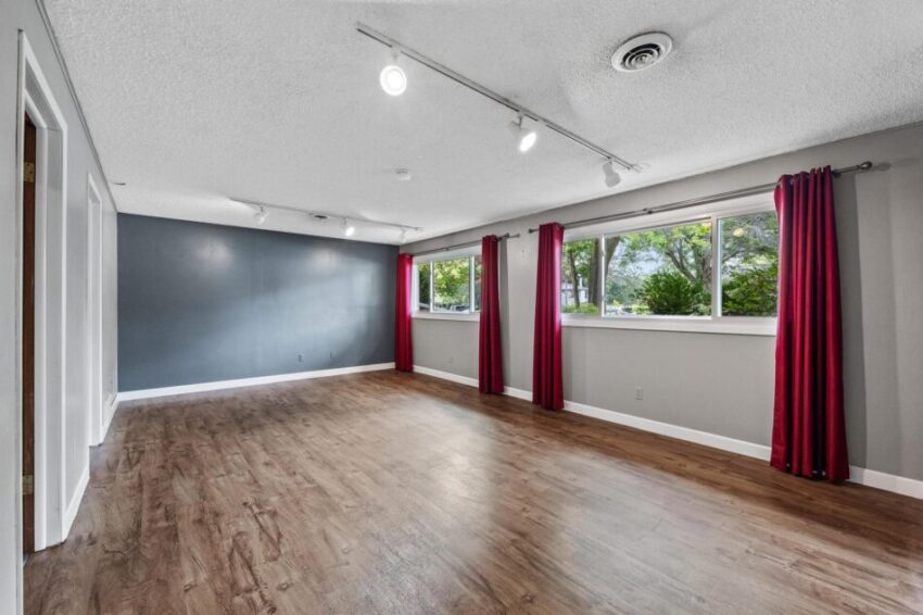 Lower level with dark blue accent wall and large windows along one side.