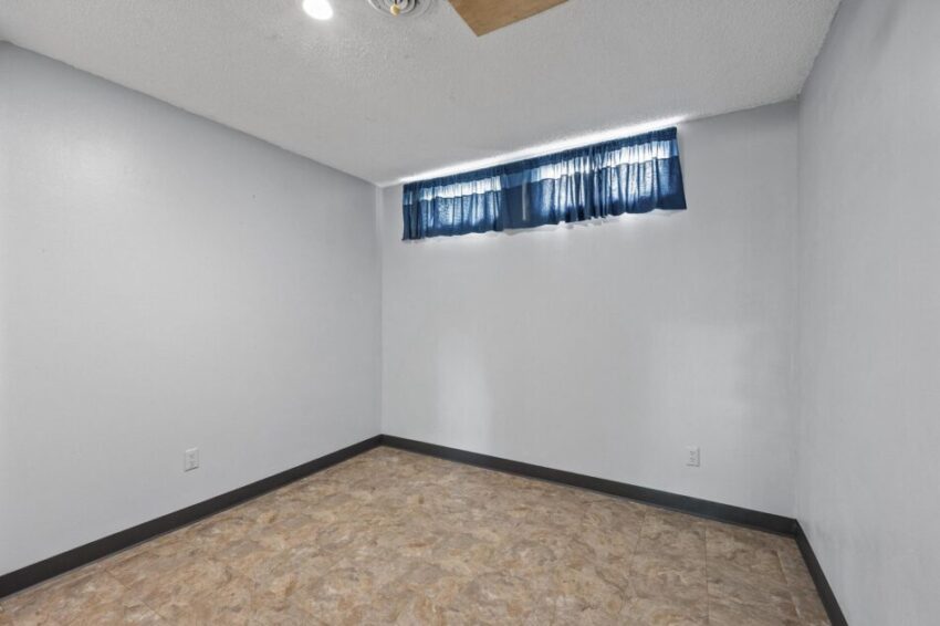 Lower level room with high windows and finished floor and ceiling.