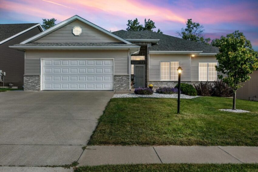 Inviting home with glowing windows and lamp post in front yard.