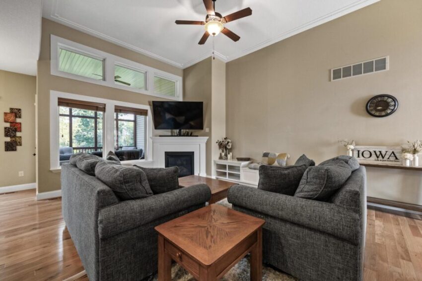 Living room with large windows, beige walls, and white trim.