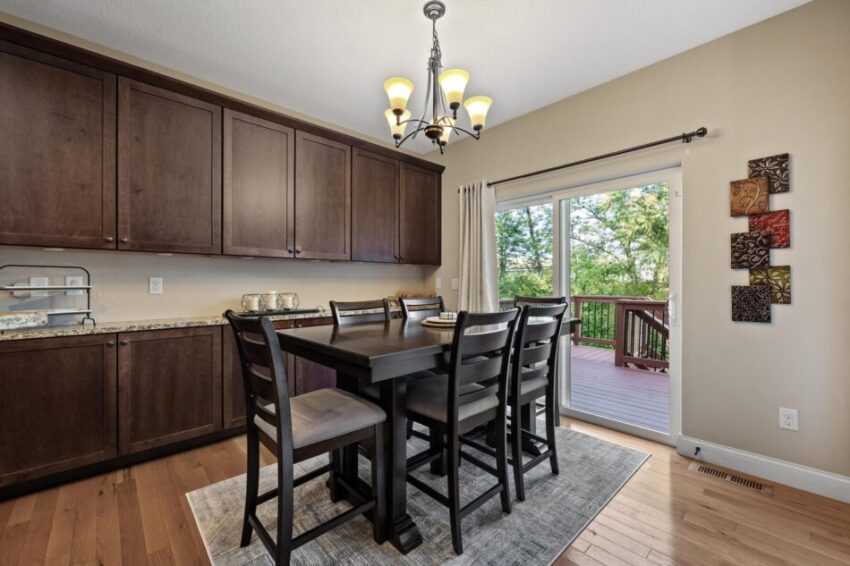 Dining area beside kitchen lined in dark wood cabinets.