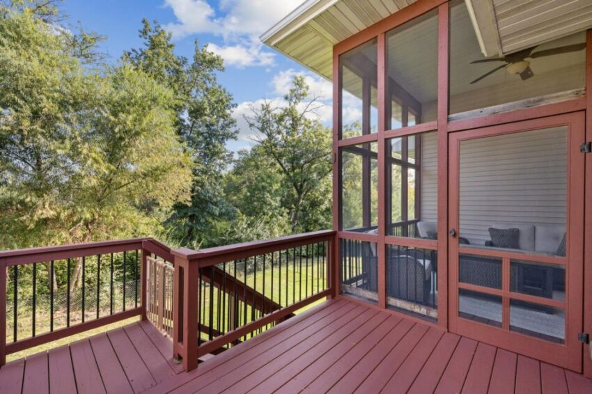 Deck outside of screen porch with stairs leading down to yard.