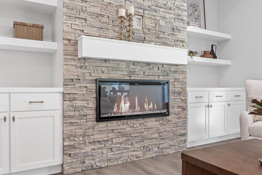 Living room with stonework surrounding fireplace.