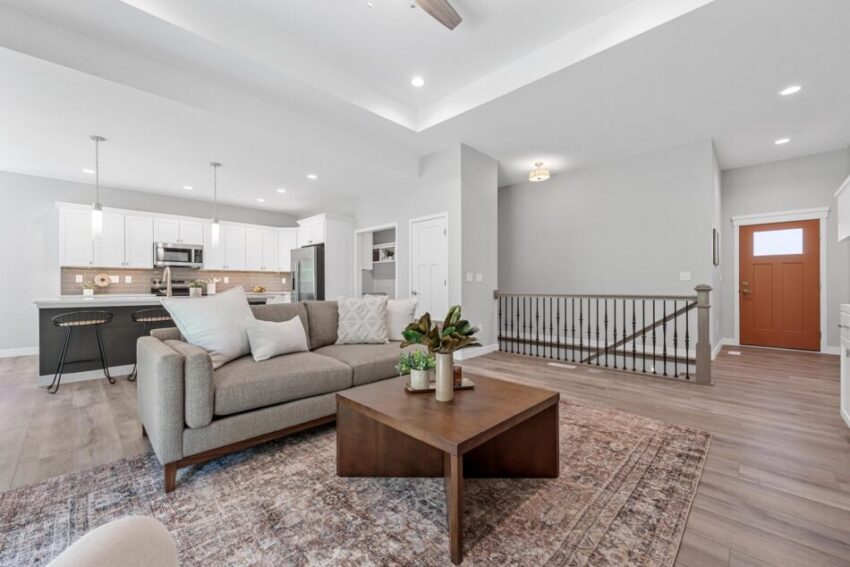 Living room with railing by staircase, light gray walls, and white trim.