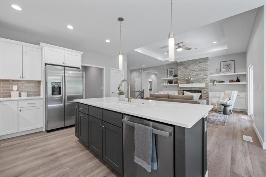 Kitchen with stainless dishwasher in island and stainless fridge.