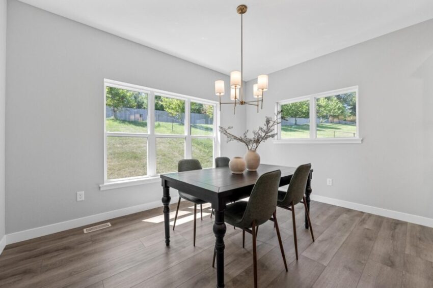 Dining room with modern vinyl flooring, light fixture, and large windows.