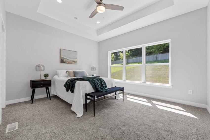 Primary bedroom, with gray carpet, light gray walls, and white trim.