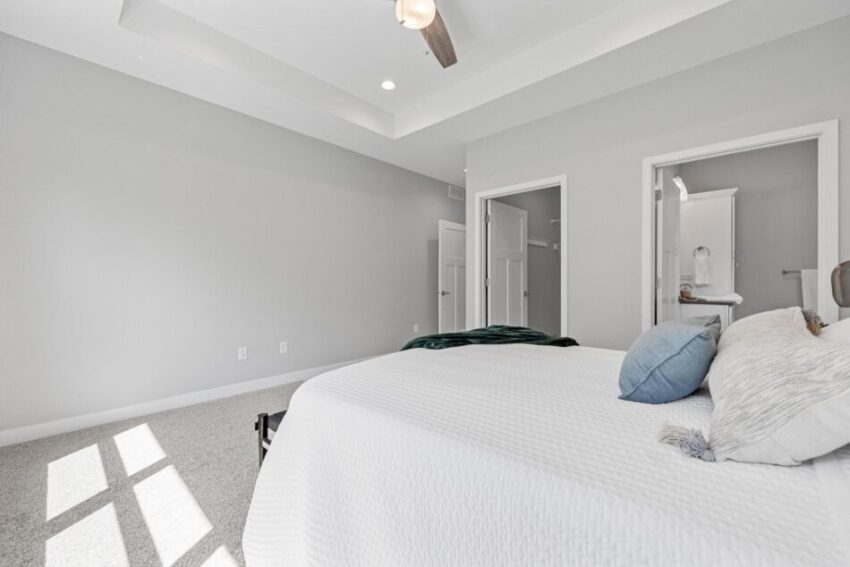 Primary bedroom with attached bath, walk-in closet, and ceiling fan.