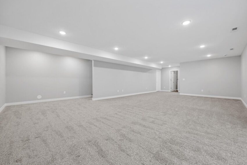 Bright and finished lower level with can lights in ceiling.