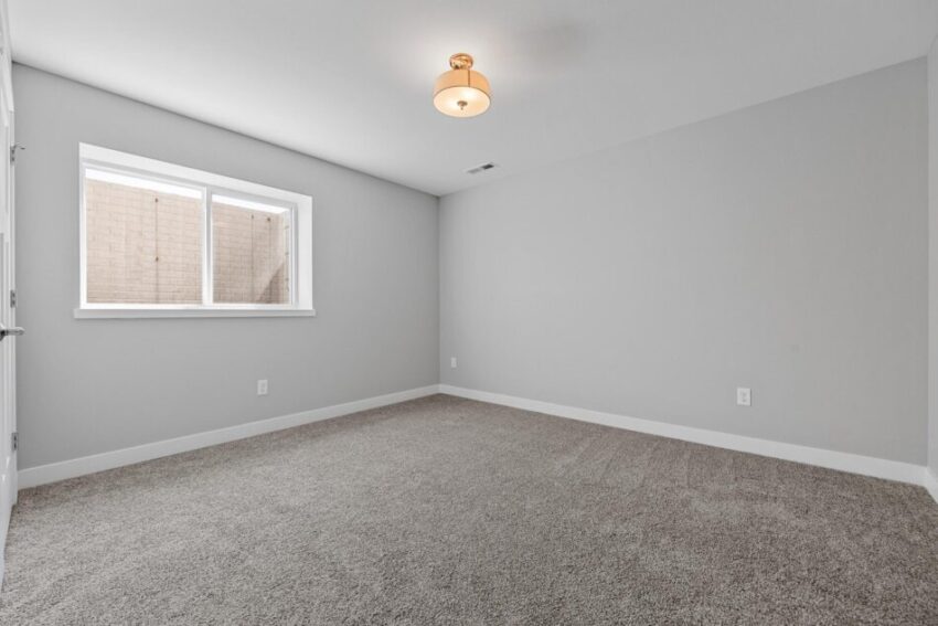 Lower level room with light fixture and window.