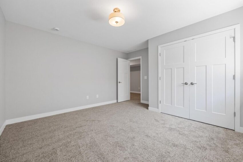 Lower level room with beige carpet, light gray walls, and white trim.