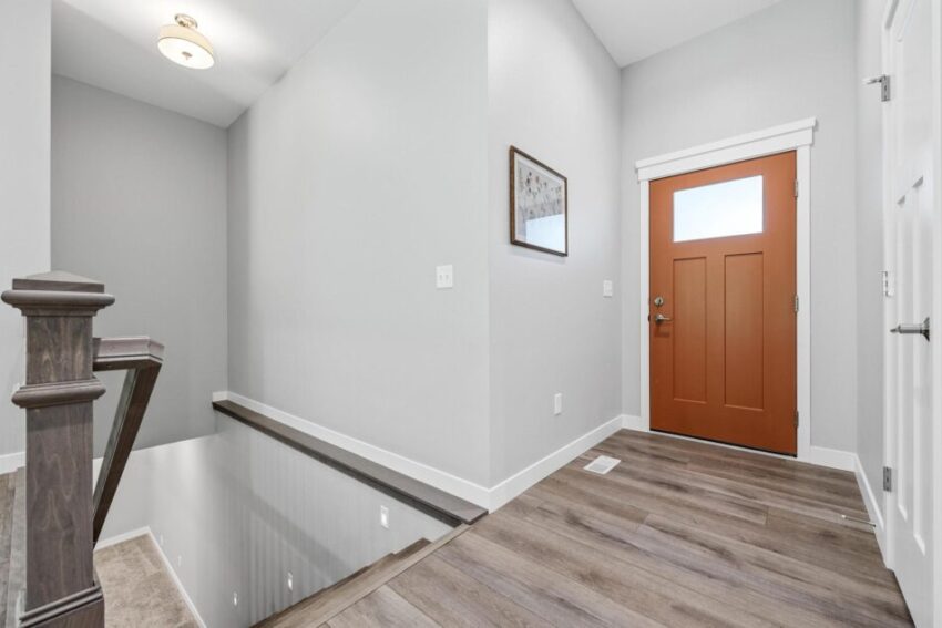Entryway with stairs leading to lower level and overhead light fixture.