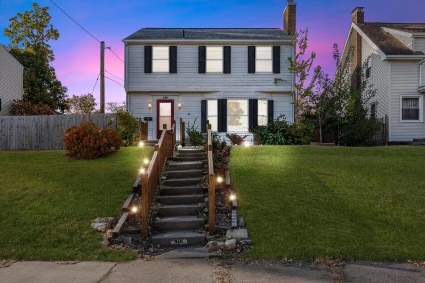 Charming home with glowing windows and a large front lawn.