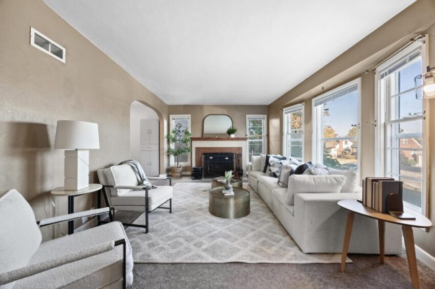 Living room with beige walls, white trim, and beautiful windows.