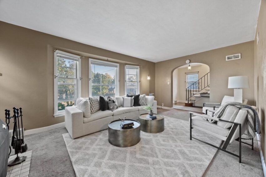 Living room with gray carpet and arched entryways.