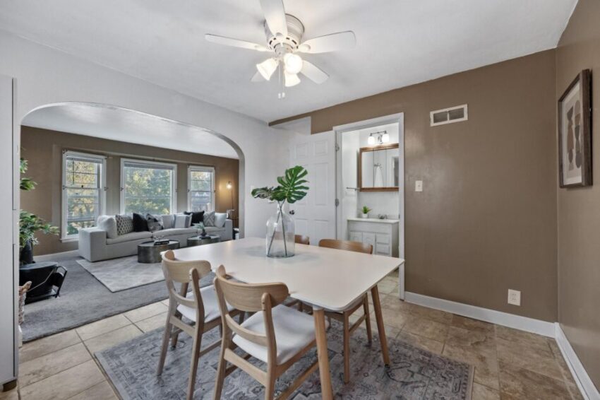 Dining room with tile floor an arched entryway into living room.