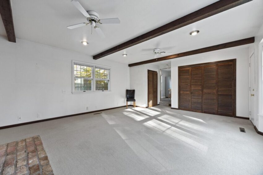 Sitting room with accent beams in ceiling and carpeted floor.
