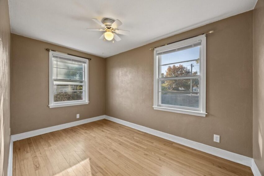 Bedroom 2, with beige walls and hardwood floor.