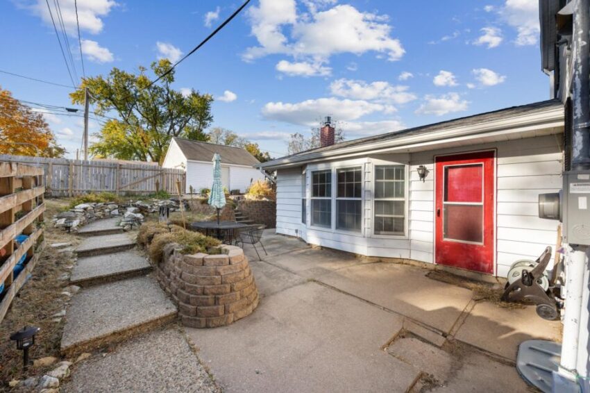 Back of house with bay windows and cheerful red door.