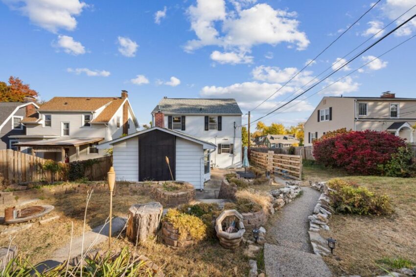 Charming view of house from the back with stone-lined pathway.
