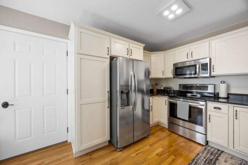 Modern kitchen with stainless steel appliances and white cabinets.