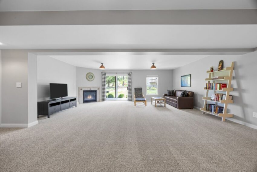 Spacious living room with fireplace, TV, sofa, and bookshelves.