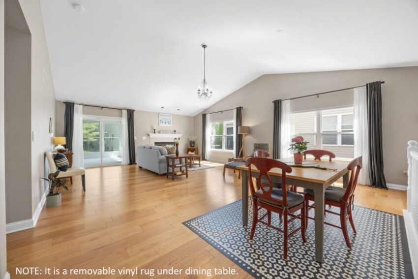 Spacious living room with dining area, wooden floor, and large windows.