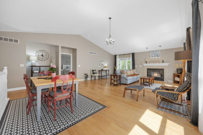 Spacious living room with dining area, fireplace, and wooden flooring.