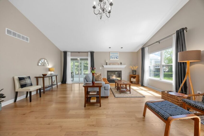 Spacious living room with hardwood floors, large windows, and modern furniture.