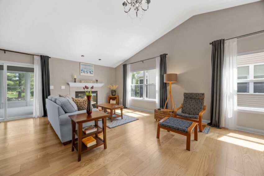 Bright living room with sofa, armchair, and large windows.