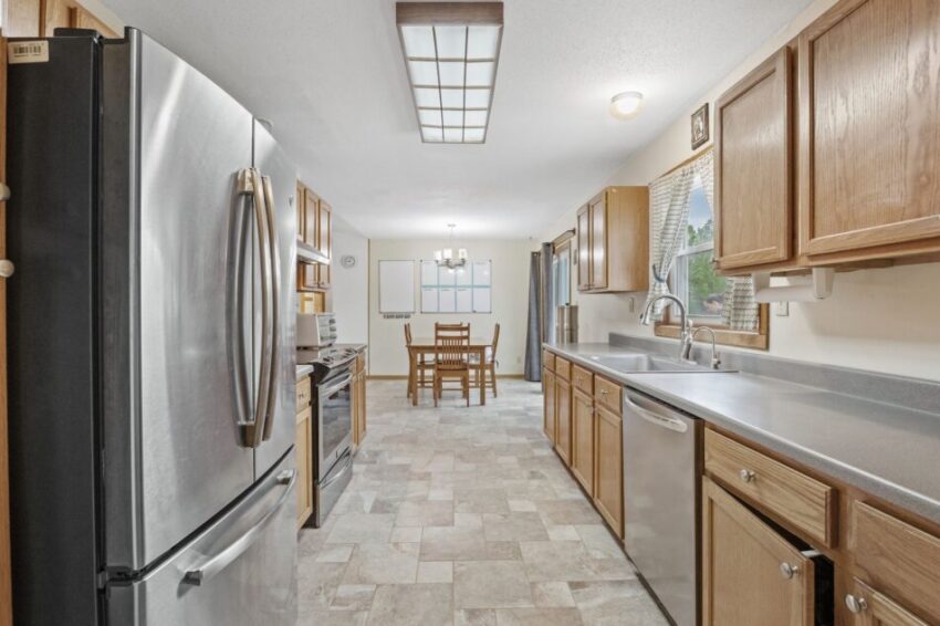 Spacious kitchen with stainless steel appliances and wooden cabinets.