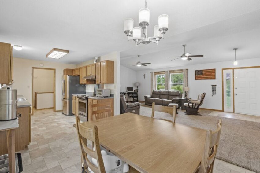 Open-concept kitchen and living room with wooden furniture and modern appliances.