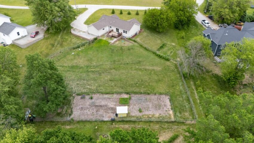 Aerial view of a house with a large backyard and garden.